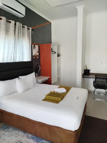 a bedroom with a large white bed with towels on it at Shalakwe Hills-Inn Guesthouse Kasane in Kasane