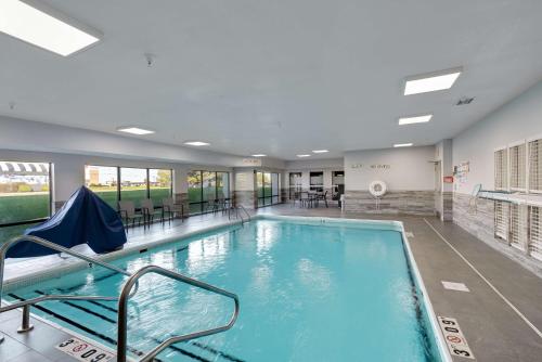 a large swimming pool with chairs and tables in a building at Hampton Inn Bloomington West in Bloomington
