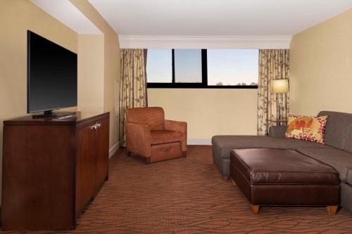 a hotel room with a couch and a tv and a chair at Hilton Orange County/Costa Mesa in Costa Mesa