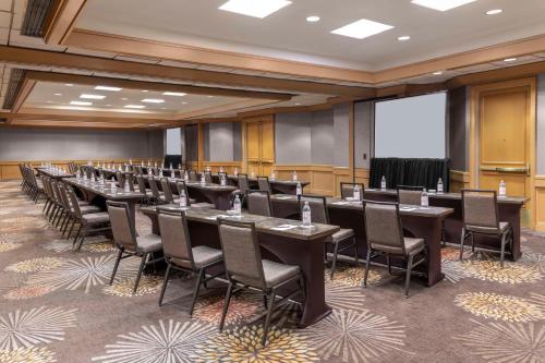 a conference room with tables and chairs and a projection screen at Hilton Orange County/Costa Mesa in Costa Mesa