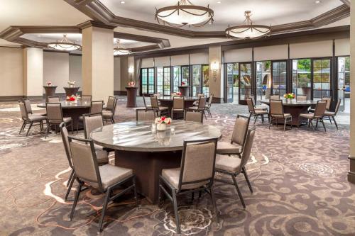a conference room with tables and chairs and windows at Hilton Orange County/Costa Mesa in Costa Mesa