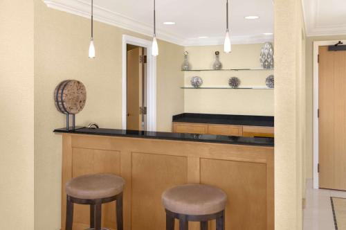 a kitchen with two stools at a bar at Hilton Orange County/Costa Mesa in Costa Mesa