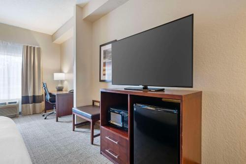 a hotel room with a large flat screen tv at Comfort Suites Downtown in Orlando