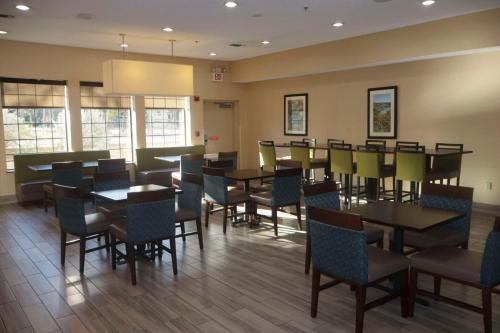 a dining room with tables and chairs and windows at Comfort Inn & Suites Burnet in Burnet