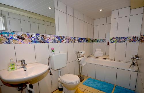 a bathroom with a sink and a toilet and a tub at Ferienwohnung Tymoshenko in Altenau