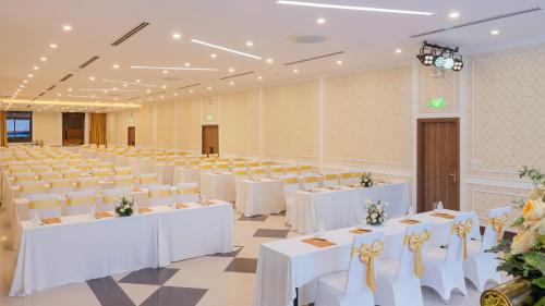 a large banquet hall with white tables and chairs at PANAMA Nha Trang Hotel in Nha Trang