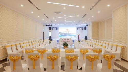 a conference room with a long table with yellow bows on it at PANAMA Nha Trang Hotel in Nha Trang