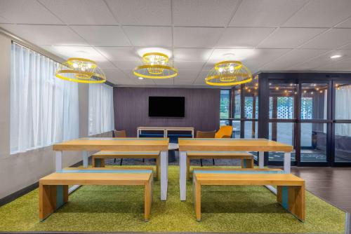 a conference room with tables and benches and a tv at Spark by Hilton Clarks Summit in Clarks Summit