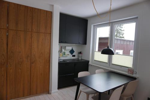 a kitchen with black cabinets and a table and a window at Muggelbude im Harz in Braunlage
