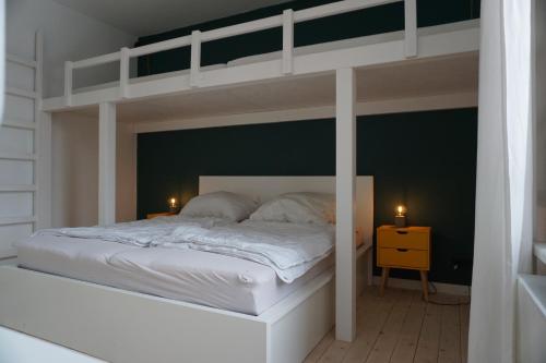 a bedroom with a white bunk bed with two candles at Muggelbude im Harz in Braunlage