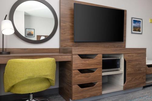 a living room with a tv and a yellow chair at Hampton Inn & Suites Porter Ranch Los Angeles in Deer Lake Highlands