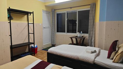 a bedroom with two beds and a window at Hotel Mystic Kakani in Kakani