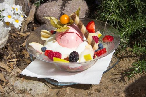 a bowl of ice cream and fruit on a table at Peter Paul Domblick Erdgeschoss in Appiano sulla Strada del Vino