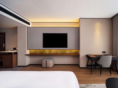 a living room with a television on a wall at Hilton Garden Inn Hefei High-Tech Zone in Hefei