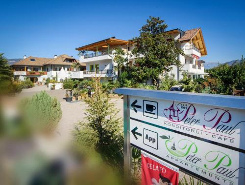 a sign in front of a building with houses in the background at Peter Paul Studio Buchwald in Appiano Sulla Strada Del Vino