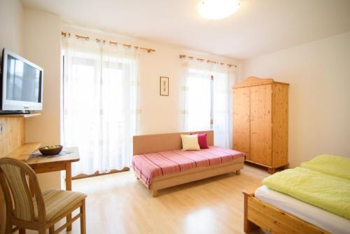 a room with a bed and a couch and a tv at Peter Paul Terrassenapp Hocheppan in Appiano Sulla Strada Del Vino