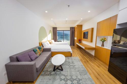 a hotel room with a couch and a bed at TMS Quy Nhơn Sea View in Quy Nhon