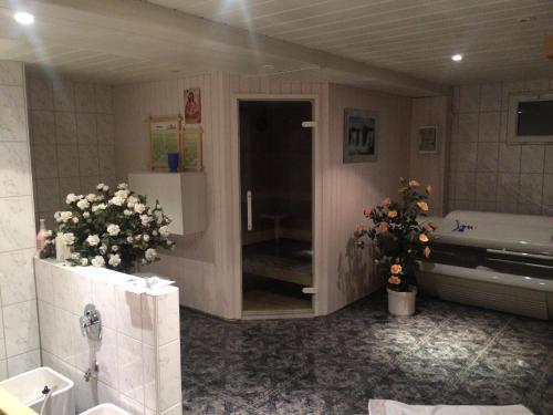 a bathroom with a tub and a sink and flowers at Landhotel Krone in Oberreute