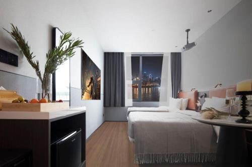 a bedroom with a bed and a table and a window at Mcsrh Hotel-Shenzhen Liutang in Shenzhen