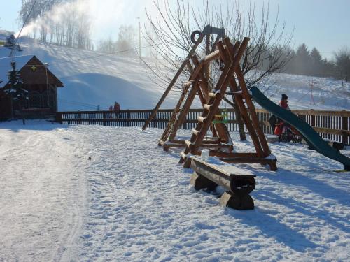 a playground in the snow with a slide at Sport-hotel Šibeniční vrch in Mnichovice