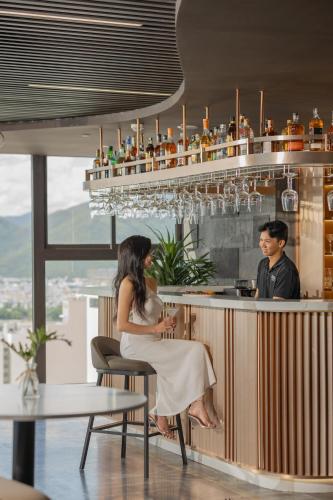 a man and a woman sitting at a bar at PANAMA Nha Trang Hotel in Nha Trang