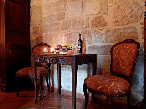 a table with a bottle of wine and two chairs at S.Nikolis' Historic Boutique Hotel in Rhodes Town