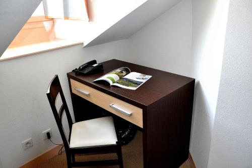 a desk in a room with a book and a chair at Hotel Les Bénédictins in Limoges