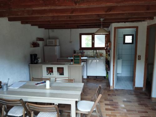une cuisine et une salle à manger avec une table et des chaises dans l'établissement grange aménagée, à Mimizan