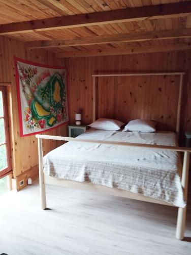une chambre avec un lit dans une pièce en bois dans l'établissement grange aménagée, à Mimizan