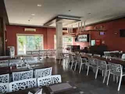 a restaurant with white chairs and tables and red walls at Ivy Bliss Studio with Private Pool, B 09, Karjat in Karjat