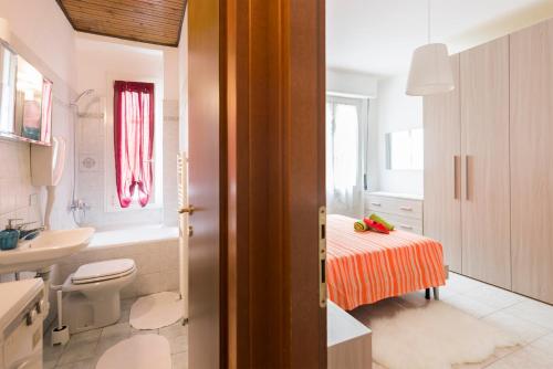 a bathroom with a bed and a sink and a toilet at Rogoredo Apartments in Milan