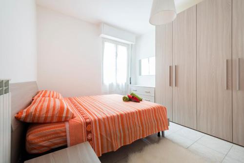 ein kleines Schlafzimmer mit einem Bett mit einer orangefarbenen Decke in der Unterkunft Rogoredo Apartments in Mailand