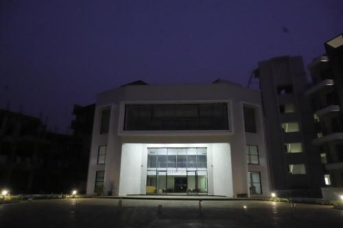 a large white building with windows at night at Ivy Bliss Studio with Private Pool, B 09, Karjat in Karjat