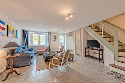 a living room with a couch and a staircase at Ty Abéric maison en front de mer in Ploudalmézeau
