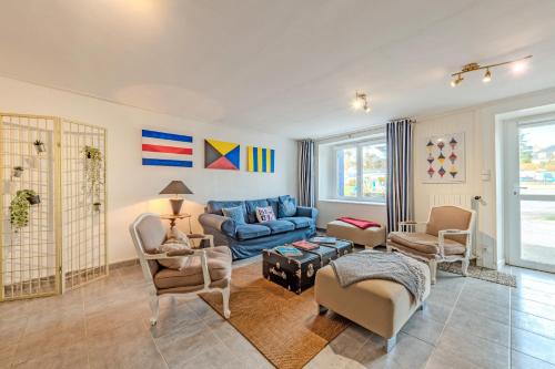 a living room with a blue couch and chairs at Ty Abéric maison en front de mer in Ploudalmézeau