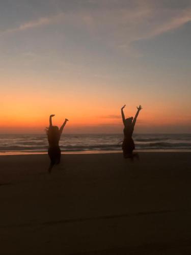 two people running on the beach at sunset at La Sataqui in Cansaulim