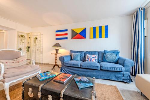 a living room with a blue couch and a table at Ty Abéric maison en front de mer in Ploudalmézeau