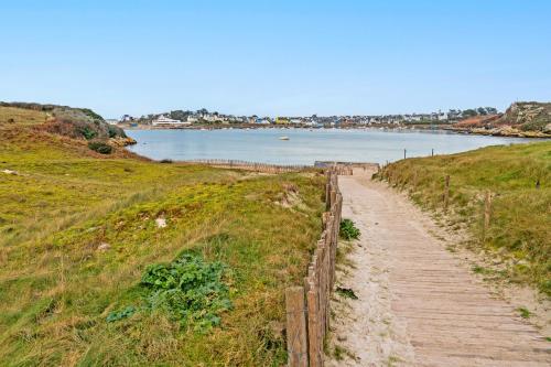 a path on a hill next to a body of water at Ty Abéric maison en front de mer in Ploudalmézeau