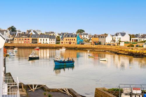 a group of boats in a river with buildings at Ty Abéric maison en front de mer in Ploudalmézeau