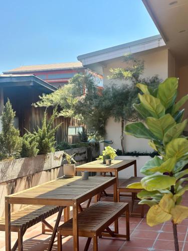 a patio with two wooden tables and benches at Your Home AYUTTHAYA in Phra Nakhon Si Ayutthaya
