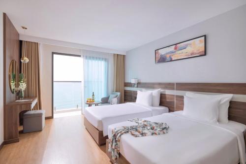 a hotel room with two beds and a window at PANAMA Nha Trang Hotel in Nha Trang