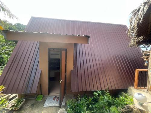 a small house with a brown roof at Jai Hidden Paradise in Romblon