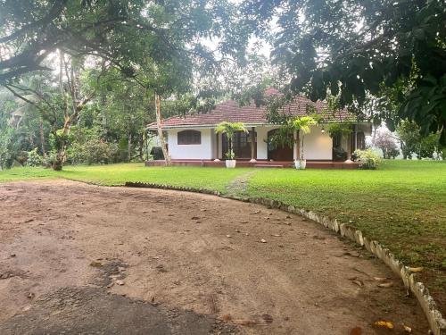 a house with a dirt road in front of it at Bellissimo Escape in Elpitiya