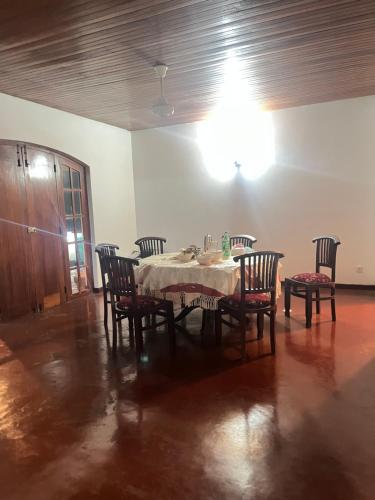a dining room with a table and chairs and a light at Bellissimo Escape in Elpitiya