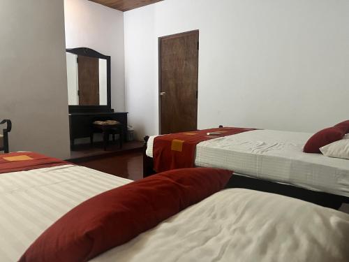 a room with two beds and a mirror at Bellissimo Escape in Elpitiya