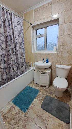 a bathroom with a toilet and a sink and a shower at Guest house in Dagenham East by Fenia in Dagenham