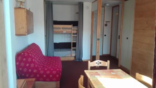 a room with a table and a chair and a bedroom at Appartement 5 personnes une chambre proche pistes balcon vue montagne Draps et serviettes non fournis Ménage à réaliser par le locataire in La Plagne Tarentaise