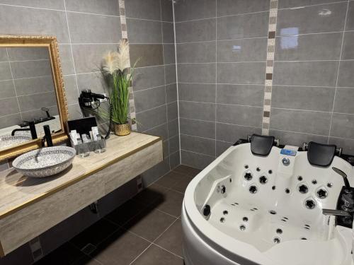 a bathroom with a tub and a sink and a mirror at HEgo in Hunedoara