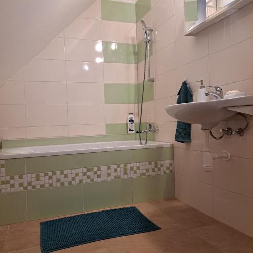 a bathroom with a bath tub and a sink at Drevenica Emma in Oravská Polhora