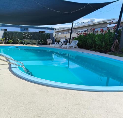 a large blue swimming pool with a canopy over it at Wangaratta Motor Inn in Wangaratta